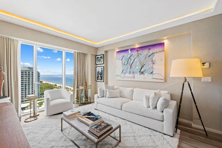 Floor-to-ceiling windows with a prominent ocean and beach backdrop