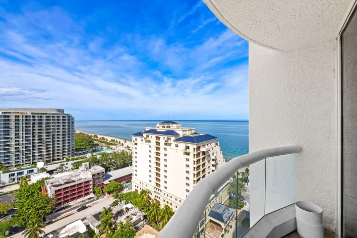 Curved balcony with glass railing, providing panoramic ocean and city views