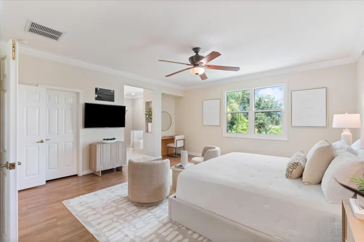 Wood-finish flooring, crown molding, double-panel interior doors, and a ceiling fan with integrated lighting