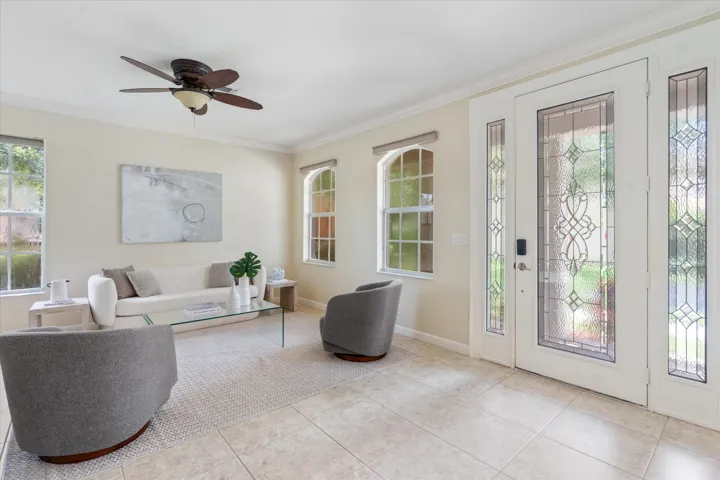 Entryway featuring a decorative glass front door with sidelights, tile flooring, and multiple windows