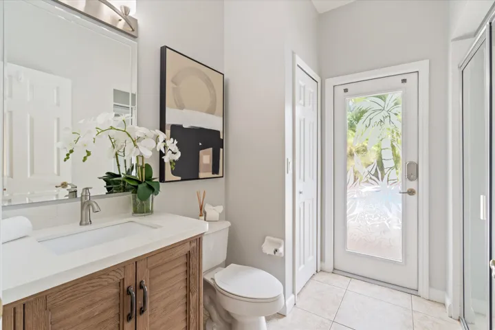 Vanity with wood-finish cabinetry, white countertop, and integrated sink