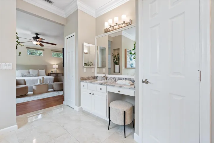 Bathroom vanity with double sinks, light-toned countertop, and white cabinetry