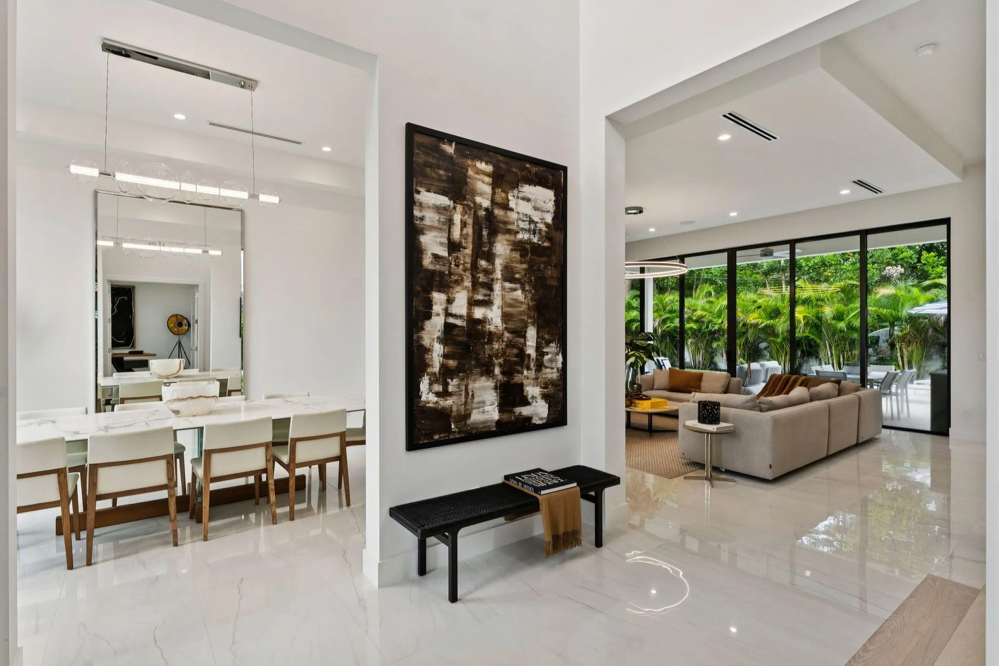 Open-concept interior featuring high ceilings, recessed lighting, expansive glass doors, and polished tile flooring