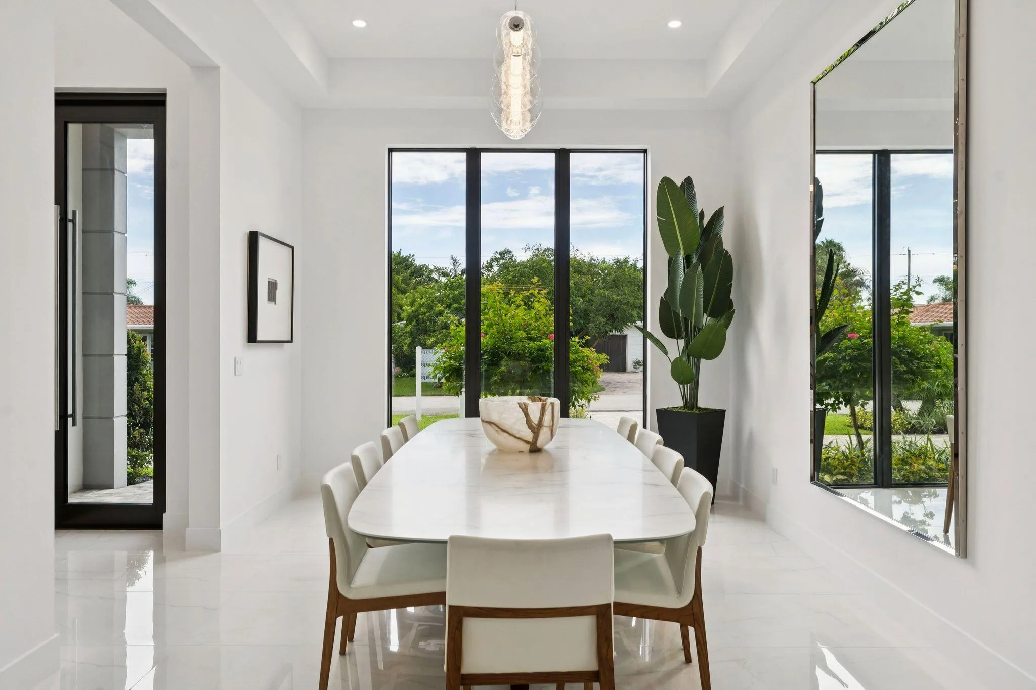 White marble-finish flooring, floor-to-ceiling windows, and a tray ceiling with recessed lighting