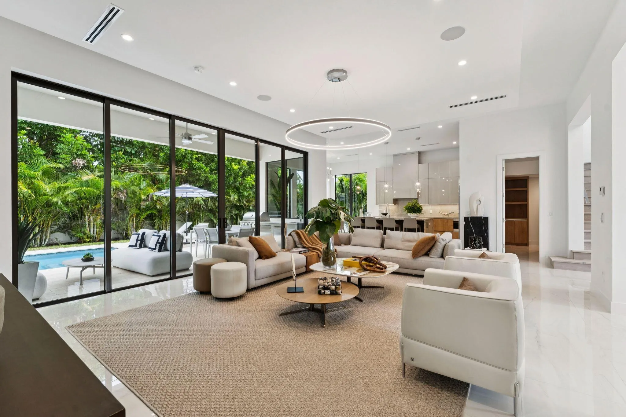 Expansive living area with large format tile flooring and recessed lighting