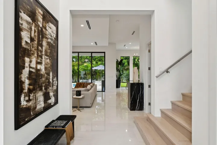 White tile flooring, recessed lighting, and a modern wood staircase with a metal handrail