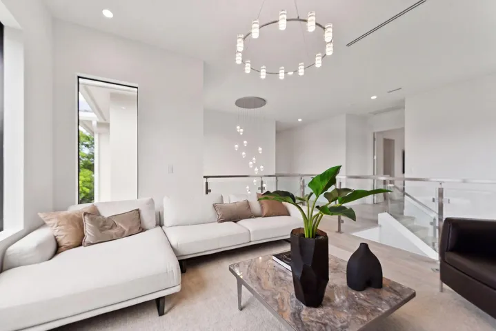 Open-concept living area with high ceilings, recessed lighting, and large vertical windows
