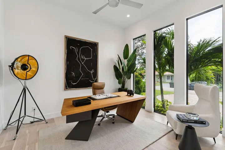 Vaulted ceiling with a ceiling fan, light wood-finish flooring, and multiple vertical windows
