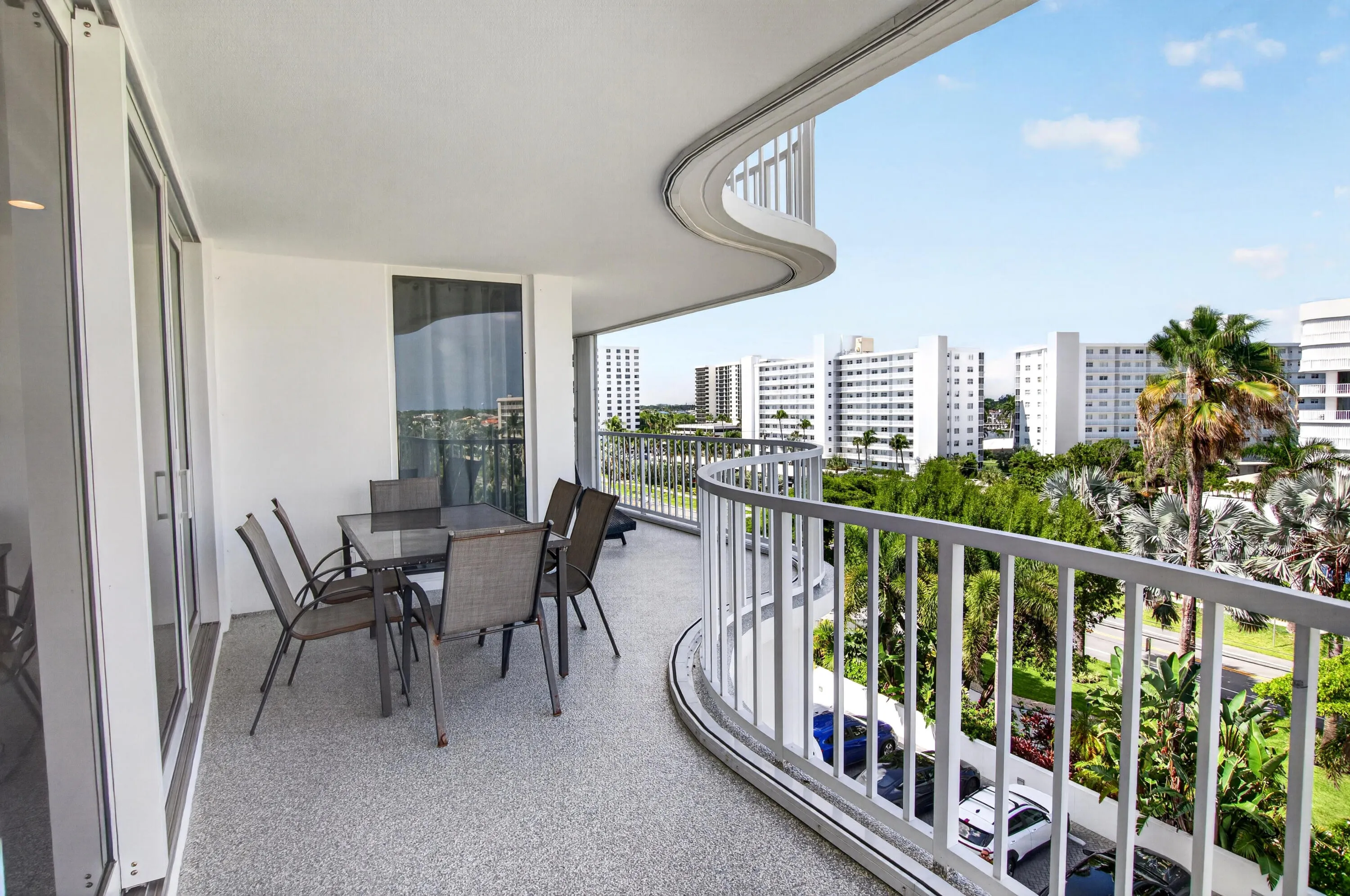Expansive curved balcony featuring a textured flooring and a sturdy railing