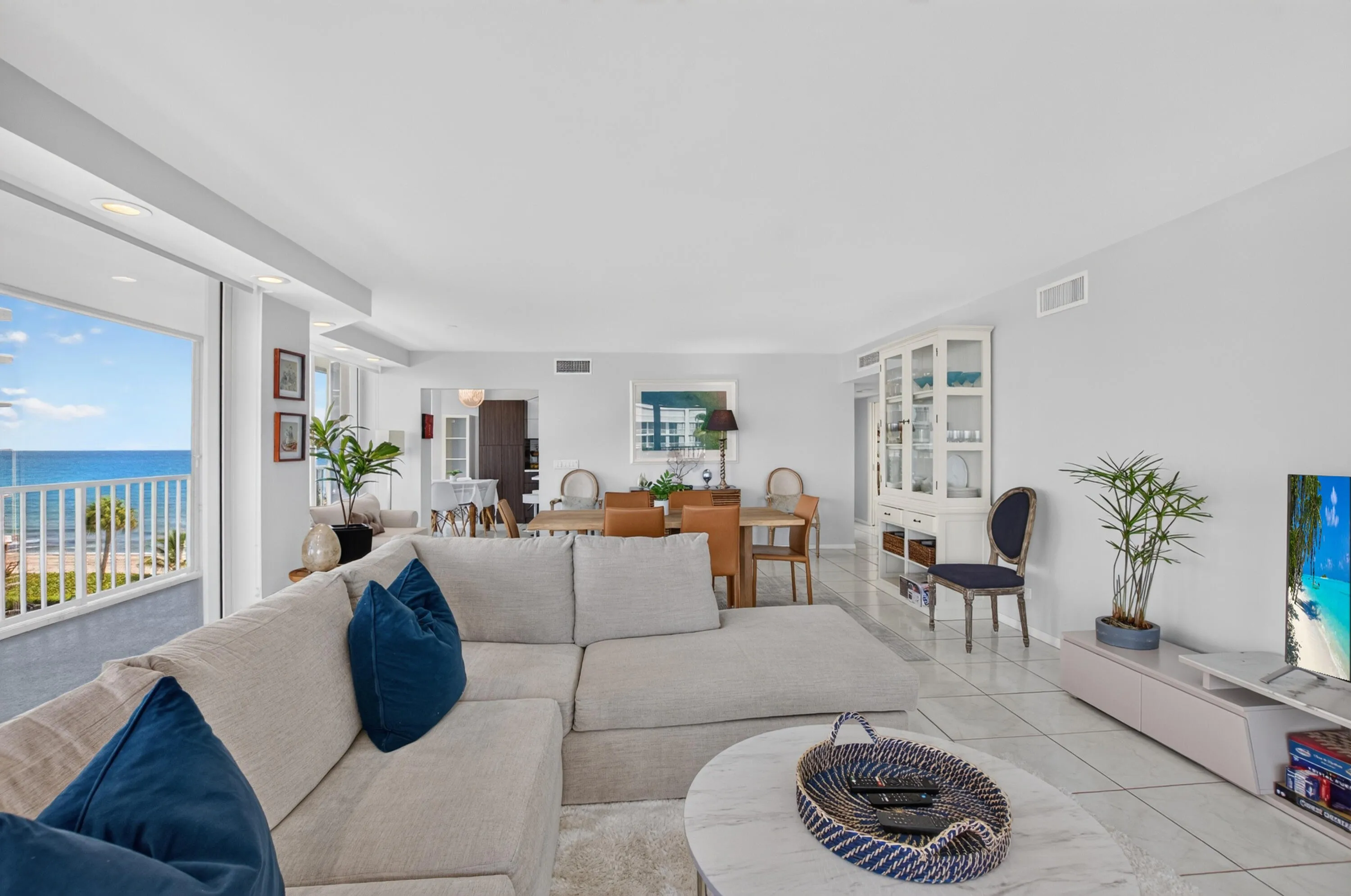 Expansive living area with large format tile flooring, a built-in display cabinet, and recessed ceiling lighting