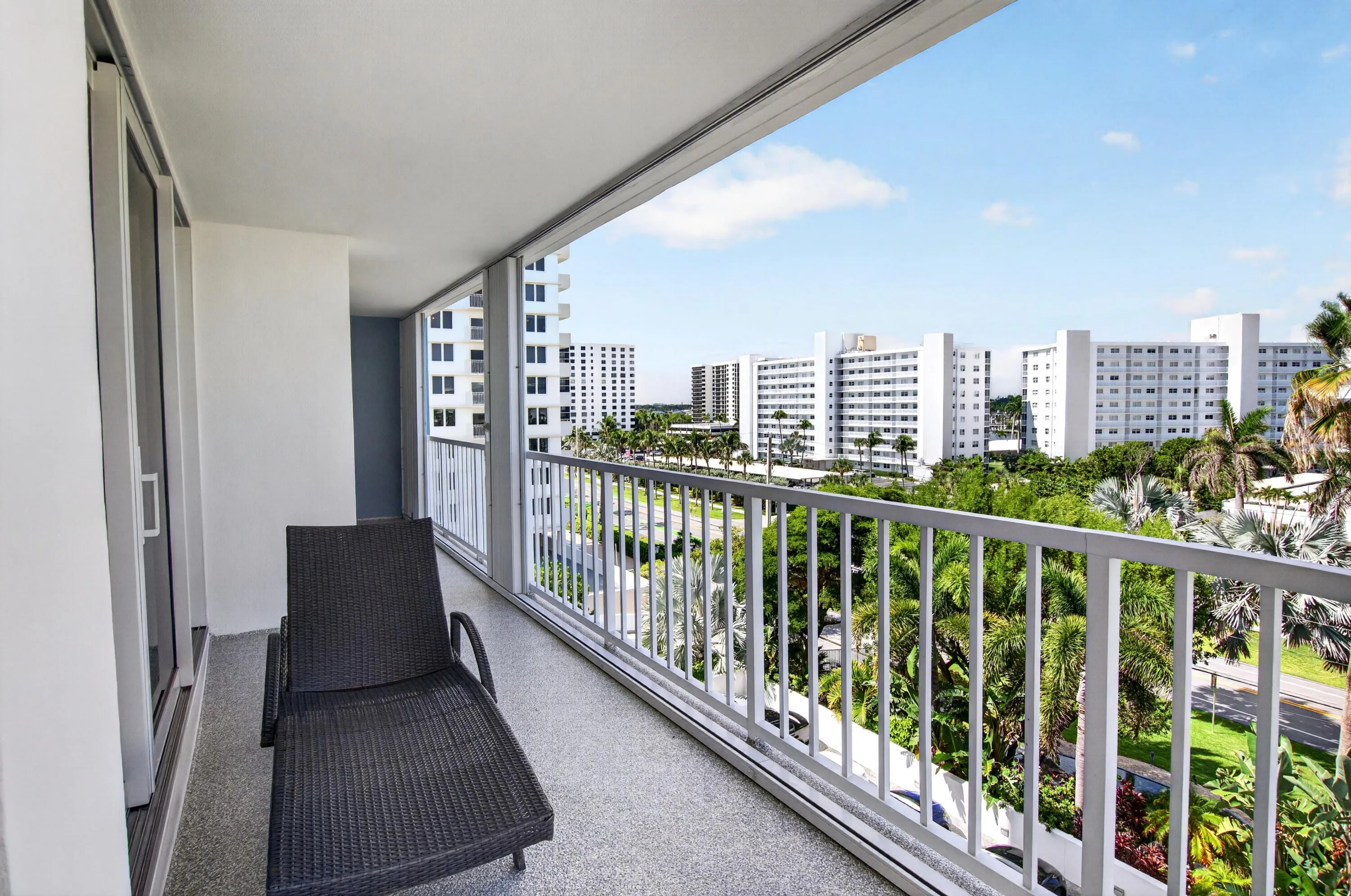 Private balcony with a textured flooring and white railing