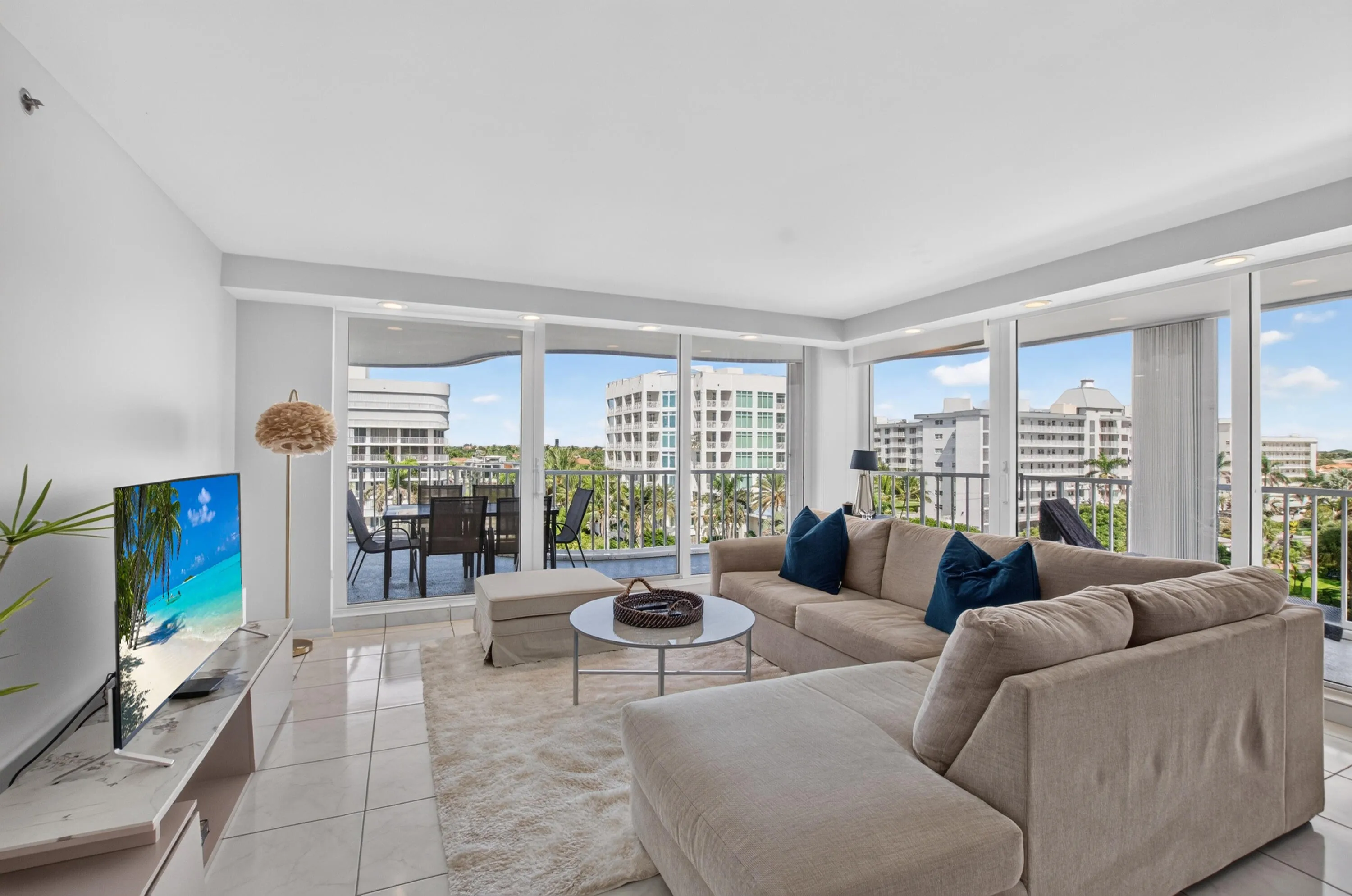 Expansive living area featuring large format tile flooring, a built-in media console, and floor-to-ceiling sliding glass doors