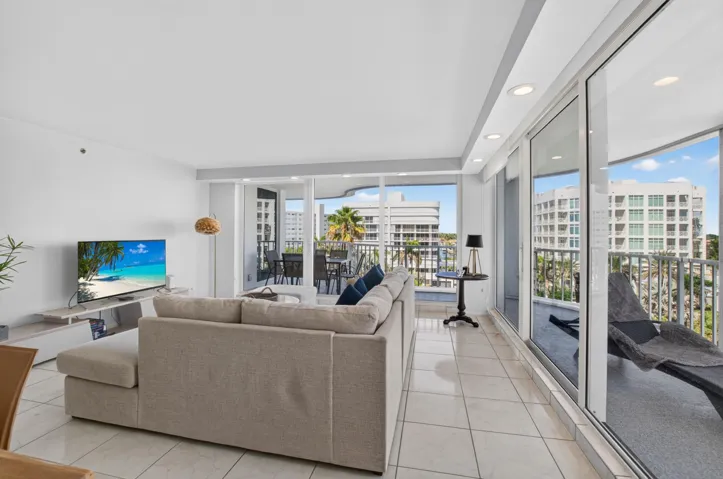 Tiled flooring throughout, recessed lighting, and expansive glass sliding doors accessing a private balcony with a metal railing
