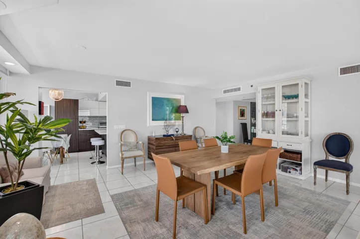 Spacious open-concept living area featuring light-toned walls and tile flooring