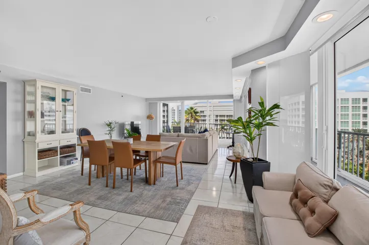 Open-concept living space with tile flooring, recessed lighting, and balcony access