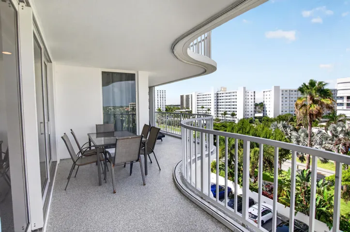 Expansive curved balcony featuring a textured flooring and a sturdy railing