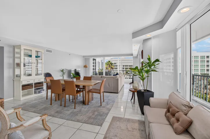 Open-concept living area featuring a built-in display cabinet, tile flooring, and direct balcony access
