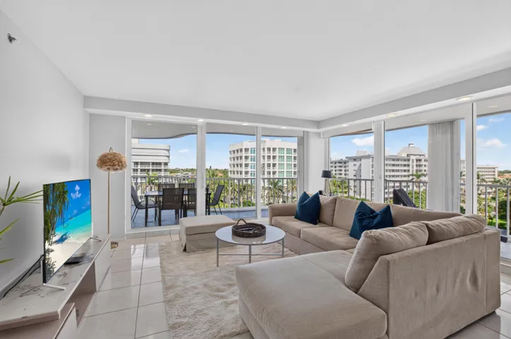Expansive living area featuring large format tile flooring, a built-in media console, and floor-to-ceiling sliding glass doors