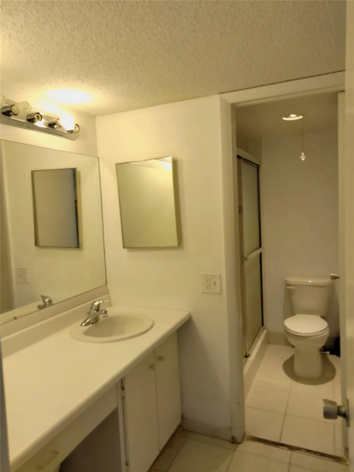 Vanity with an integrated sink, dual mirrors, and a chrome light fixture