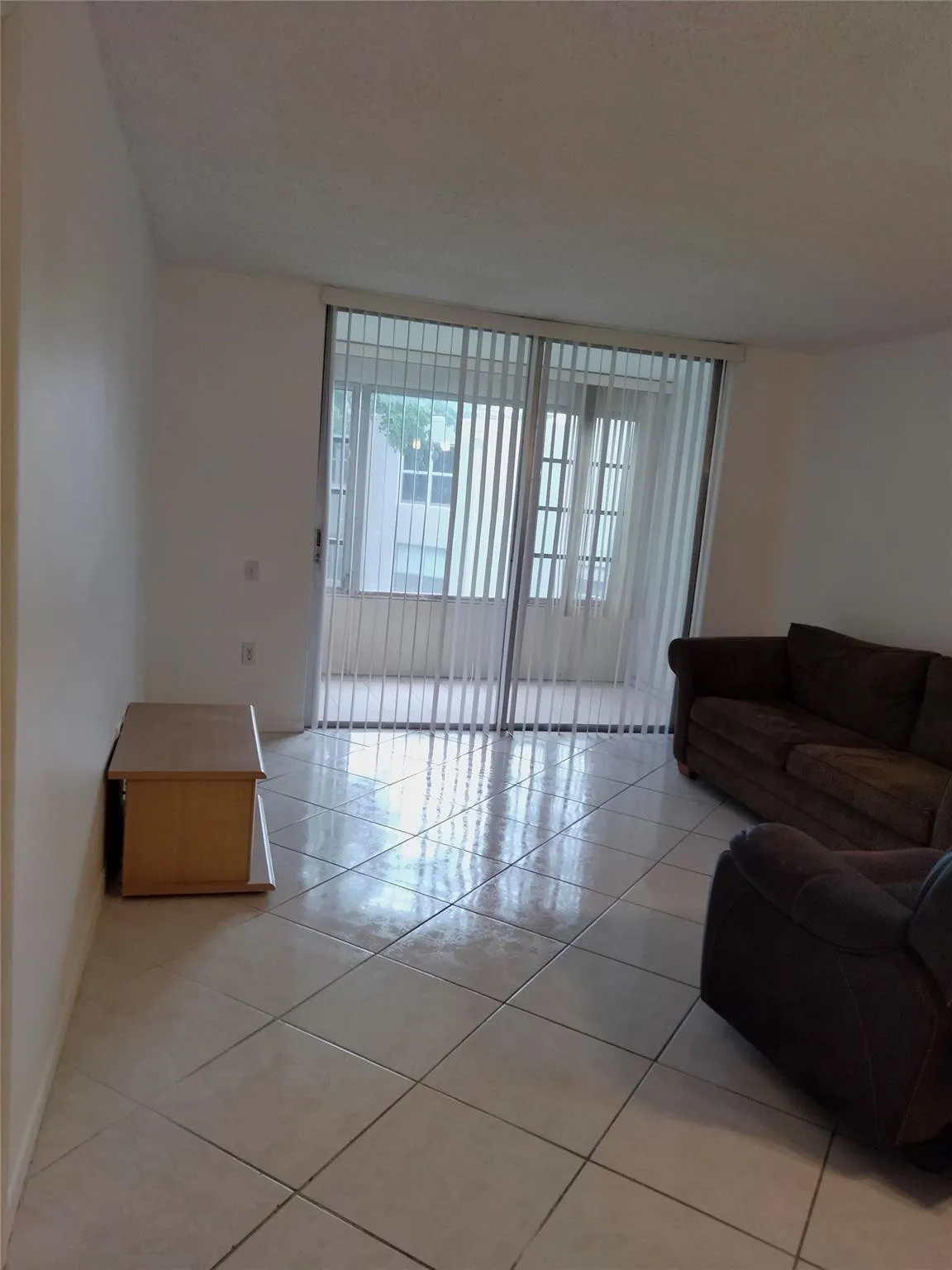 White tile flooring, sliding glass doors, vertical blinds, white walls, smooth ceilings