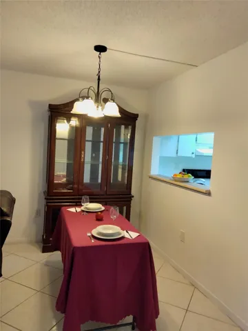 Pass-through window, overhead lighting fixture, and tile flooring