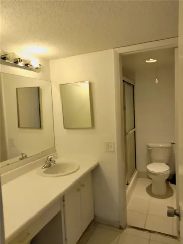 Vanity with an integrated sink, dual mirrors, and a chrome light fixture
