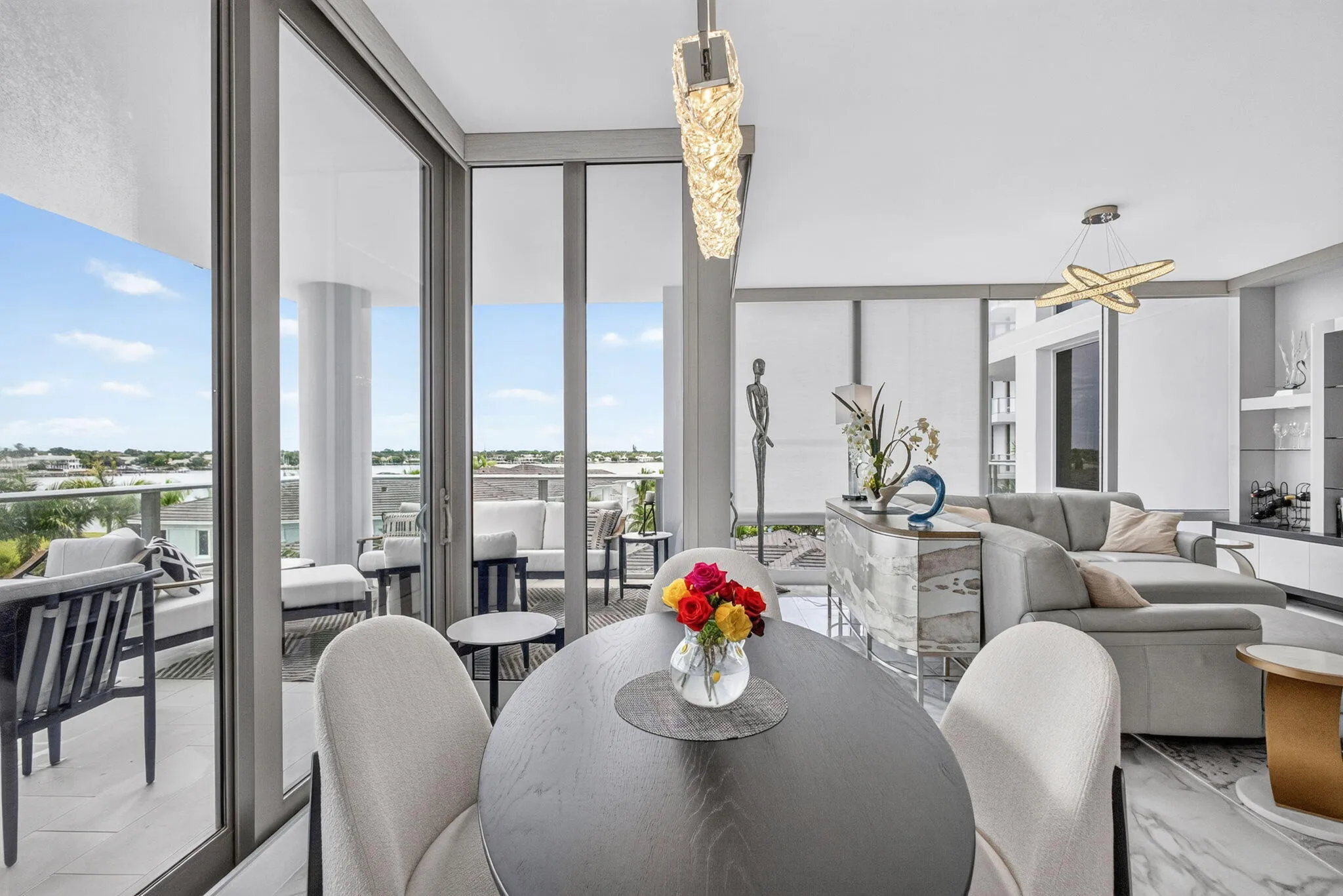 Expansive sliding glass doors, contemporary pendant lighting, a built-in bar with a stone-finish counter, and polished tile flooring