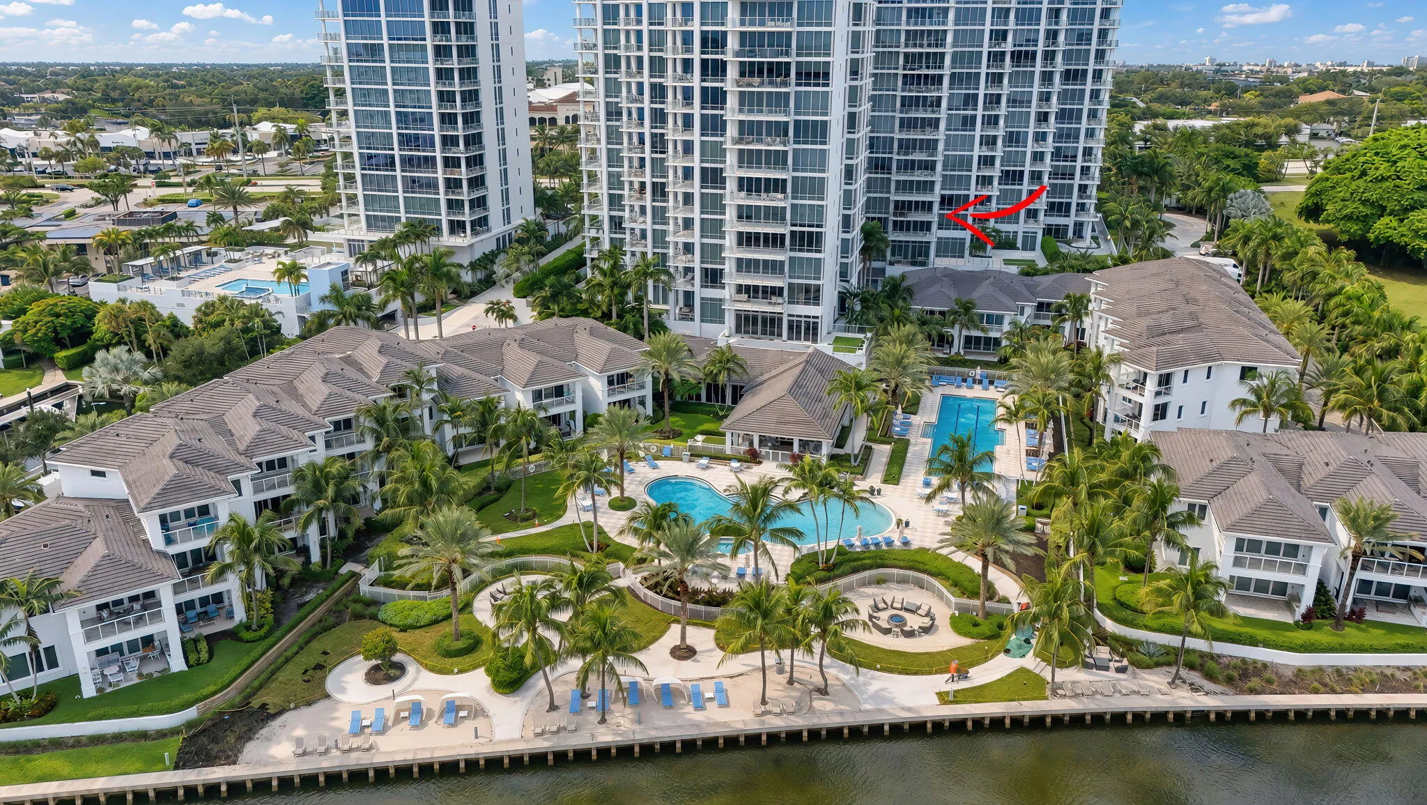 HIGH-END RESORT STYLE Waterfront multi-building complex featuring 3 swimming pools, multiple outdoor seating areas, and lucious landscaping