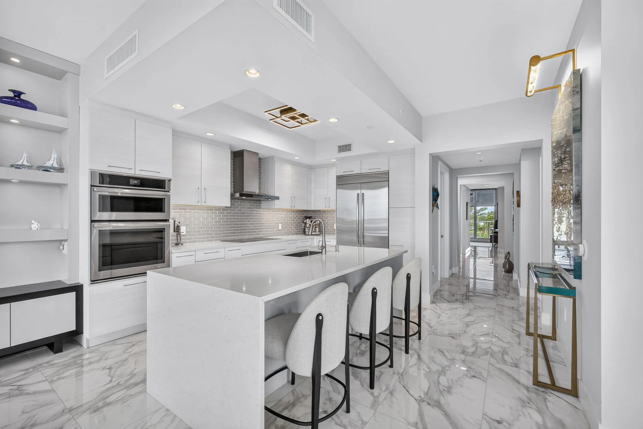 Modern kitchen has custom modern cabinetry with designer backsplash, upscale appliances, sink in island all with a Fab view!