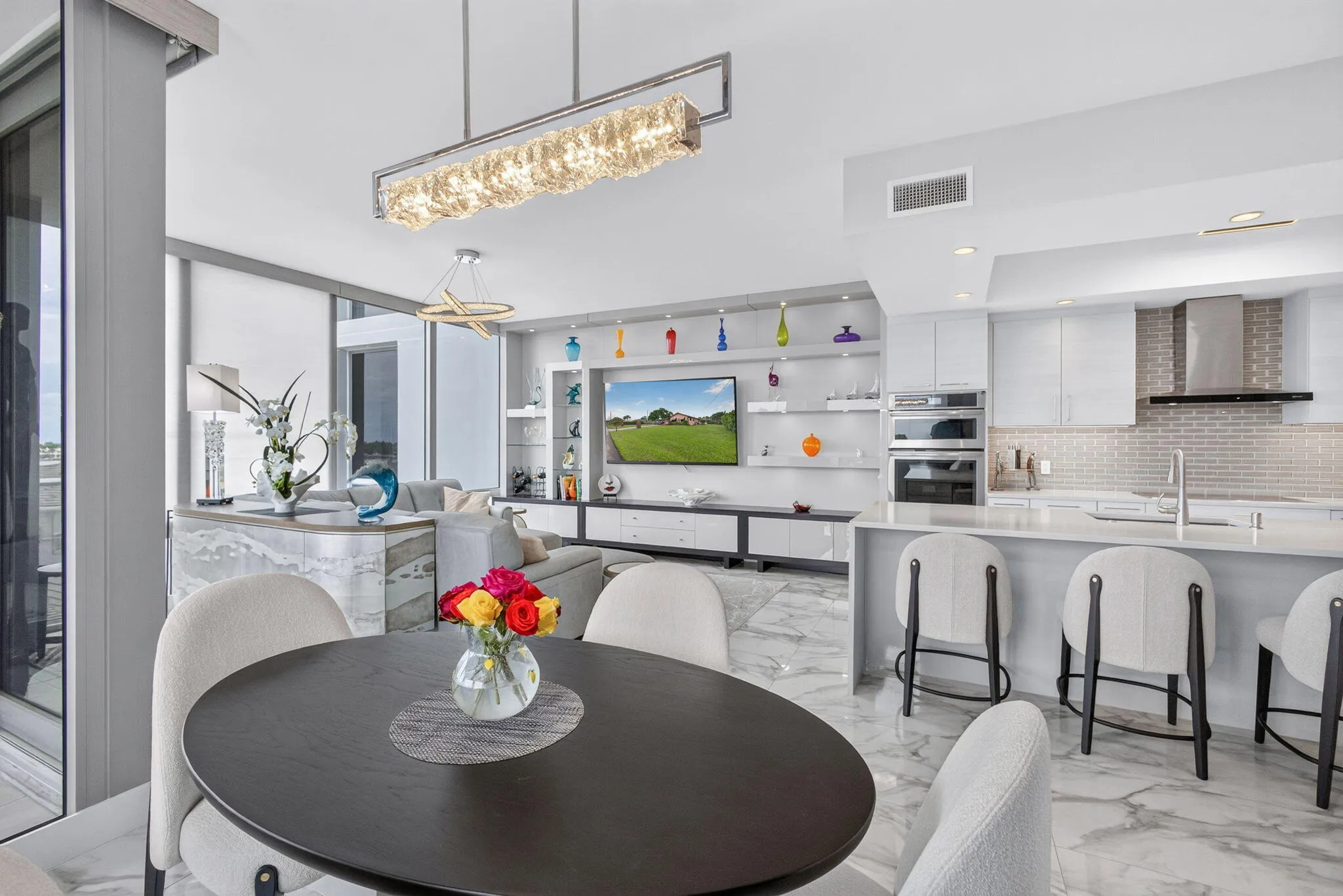 Modern kitchen featuring integrated appliances, light-toned cabinetry, and a textured tile backsplash