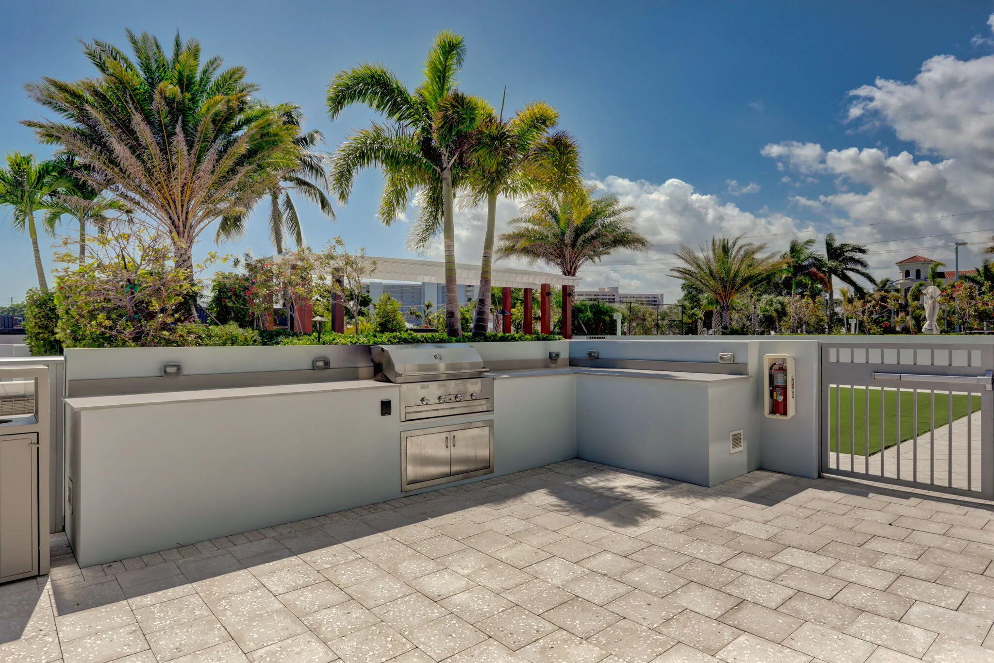 Paver patio featuring an outdoor kitchen with built-in grill, integrated cabinetry, and perimeter wall