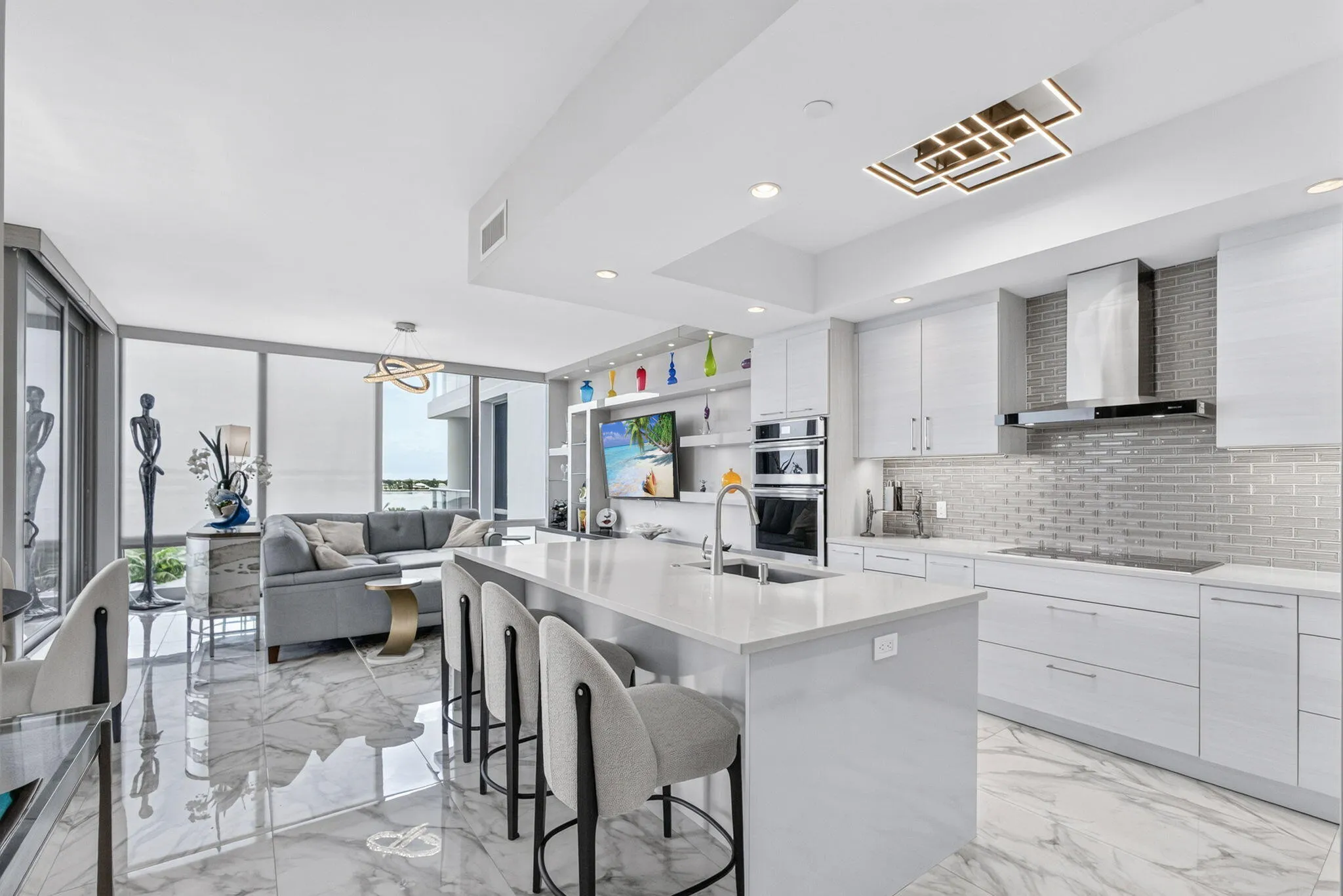 Open-concept living space featuring high ceilings, large format tile flooring, and floor-to-ceiling windows