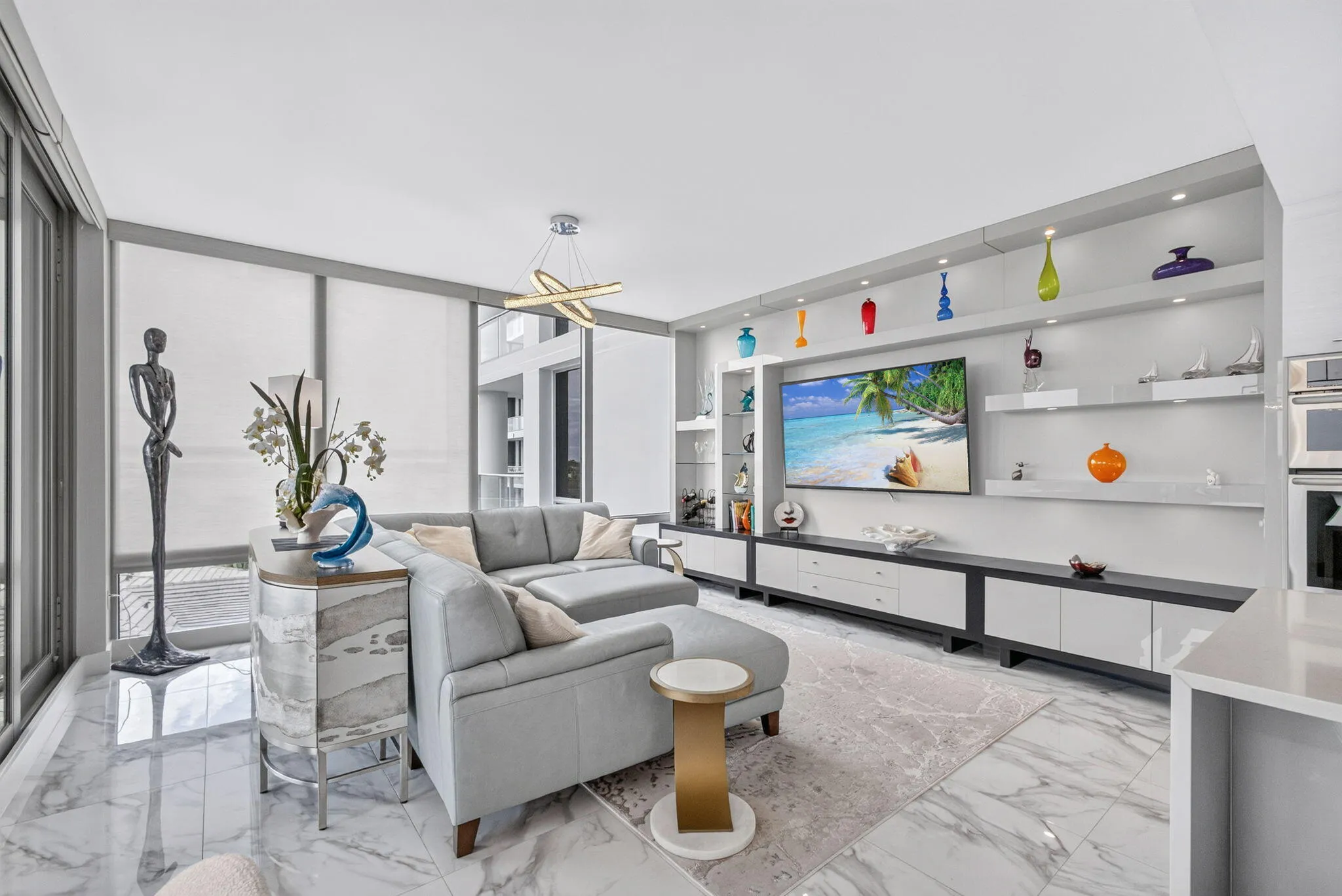 Huge great room featuring large format tile flooring, built-in custom media center with open shelving, recessed lighting. Custom remote controlled window shades on all sliding doors and windows, dim the lights....bring out the popcorn and enjoy the movie!