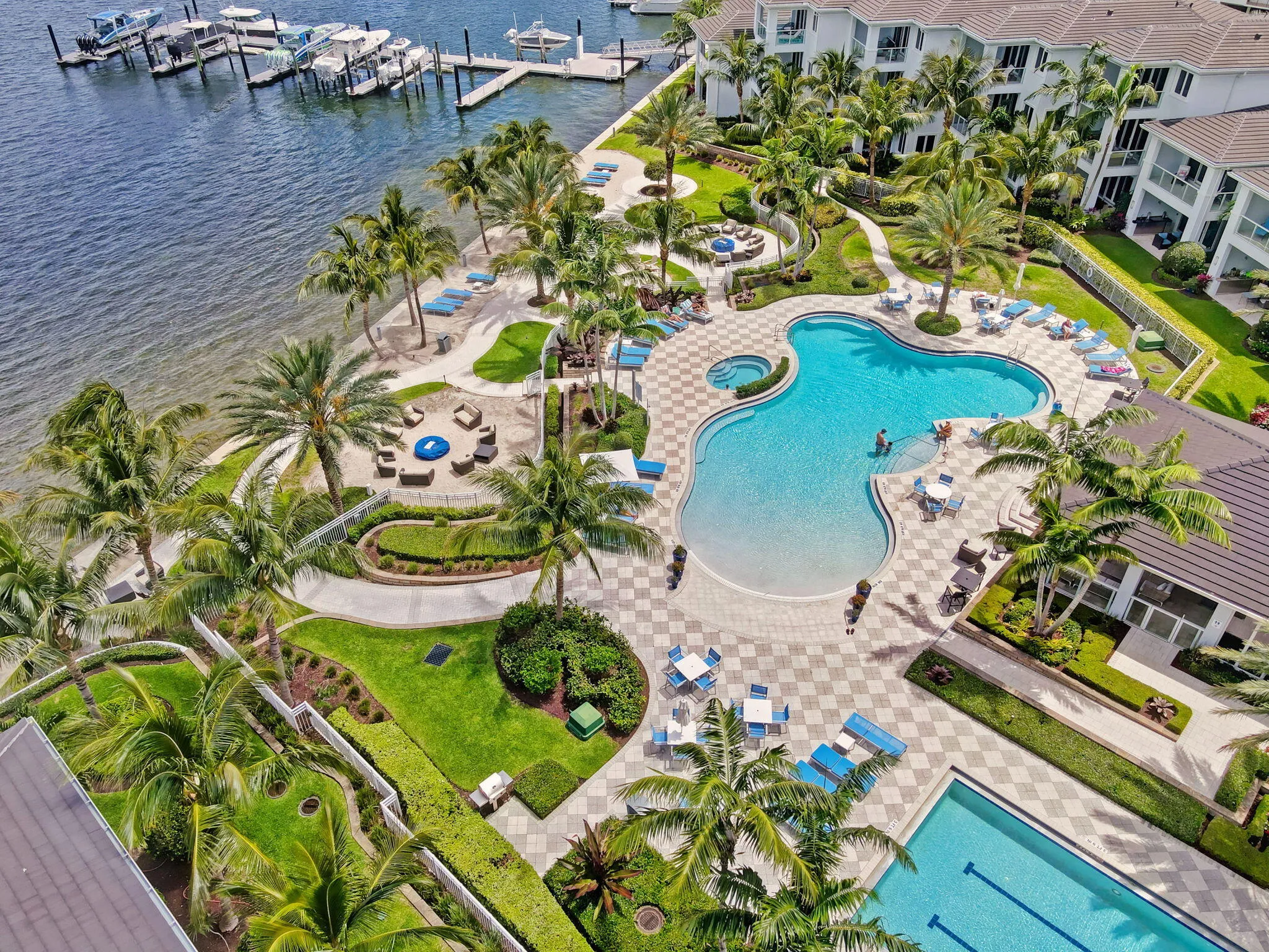 Marina access with multiple boat slips, two resort-style pools, a dedicated lap pool, and a fire pit area