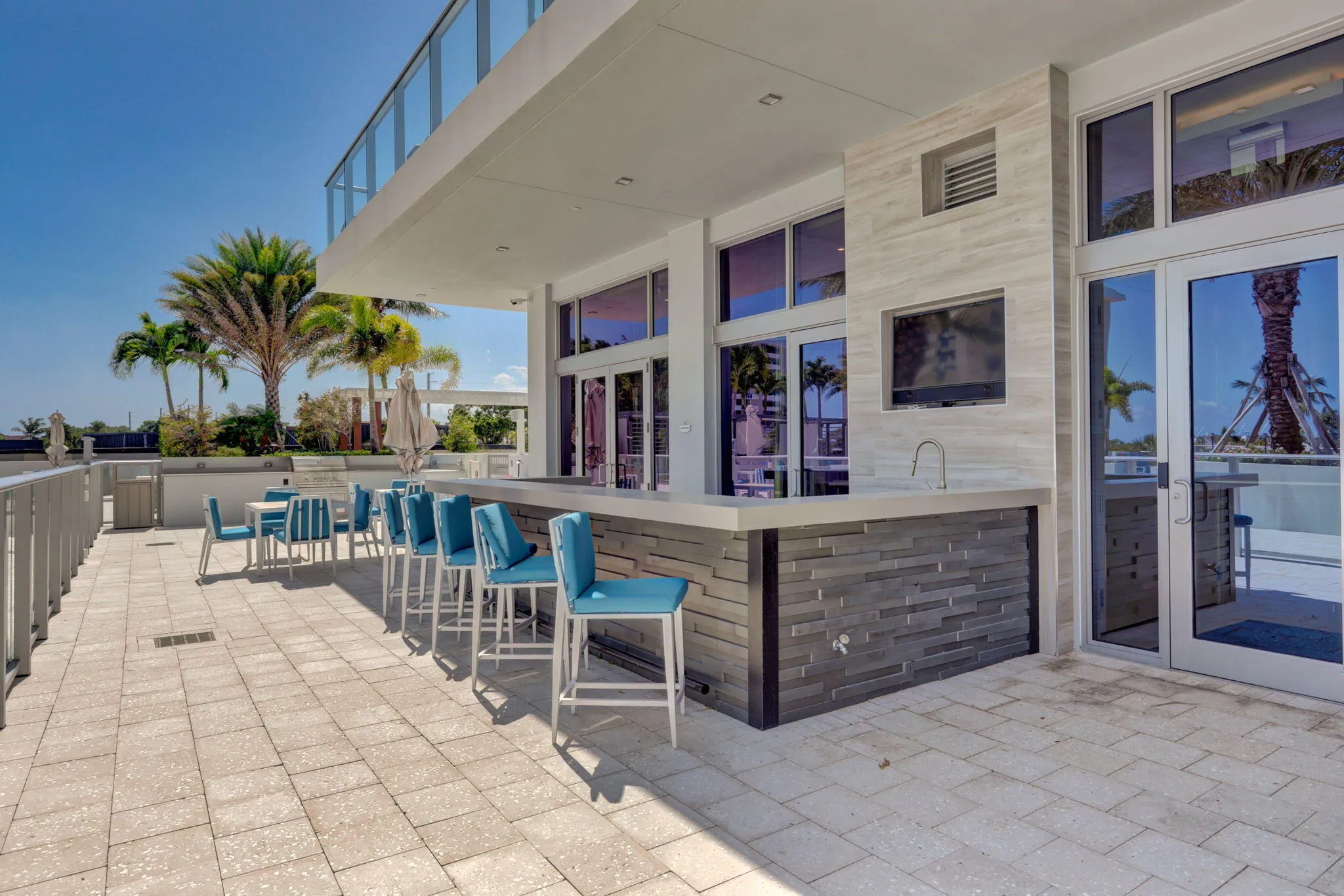 Outdoor entertainment area with a built-in bar, integrated sink, and an outdoor television