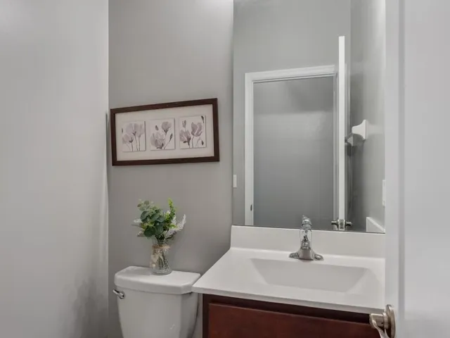 Powder room featuring a single vanity with a white countertop and wood-finish cabinetry