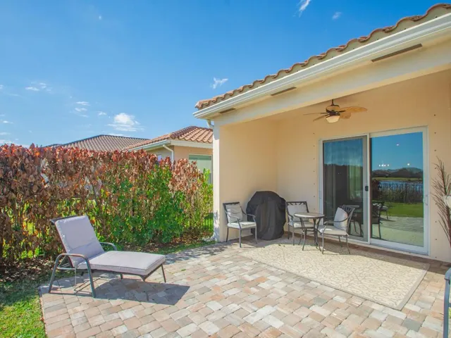 Covered patio featuring a ceiling fan, sliding glass doors, and a decorative outdoor rug