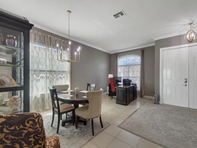 Interior space featuring tile flooring, neutral wall paint, and crown molding