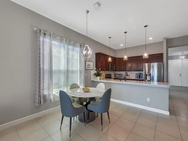 Kitchen area featuring dark wood cabinetry, stainless steel appliances, and a light-toned countertop