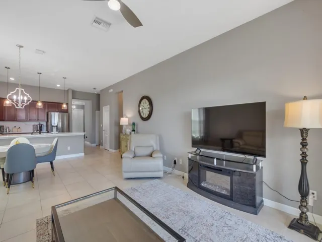 Open-concept living space with light neutral wall tones and tile flooring throughout