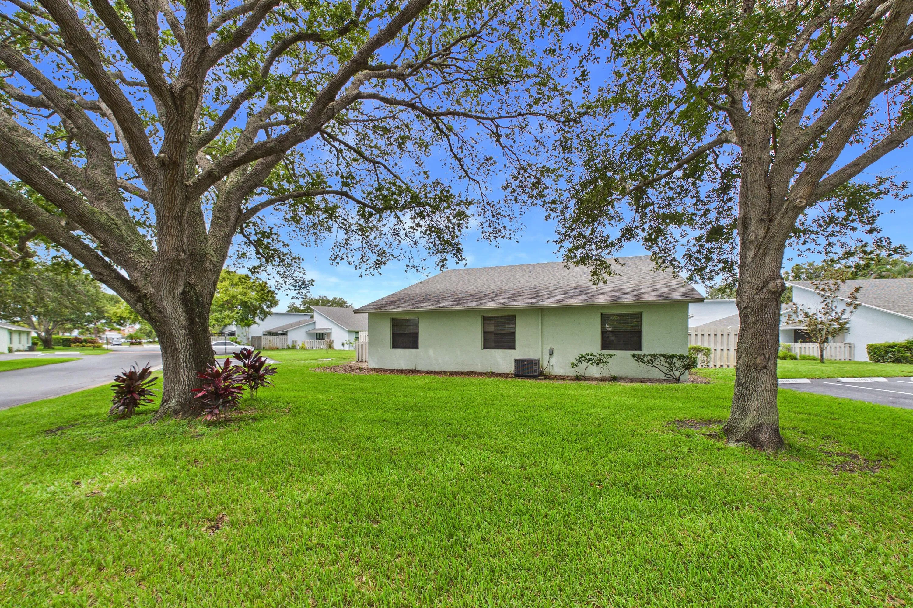 Expansive lawn with mature trees and established landscaping