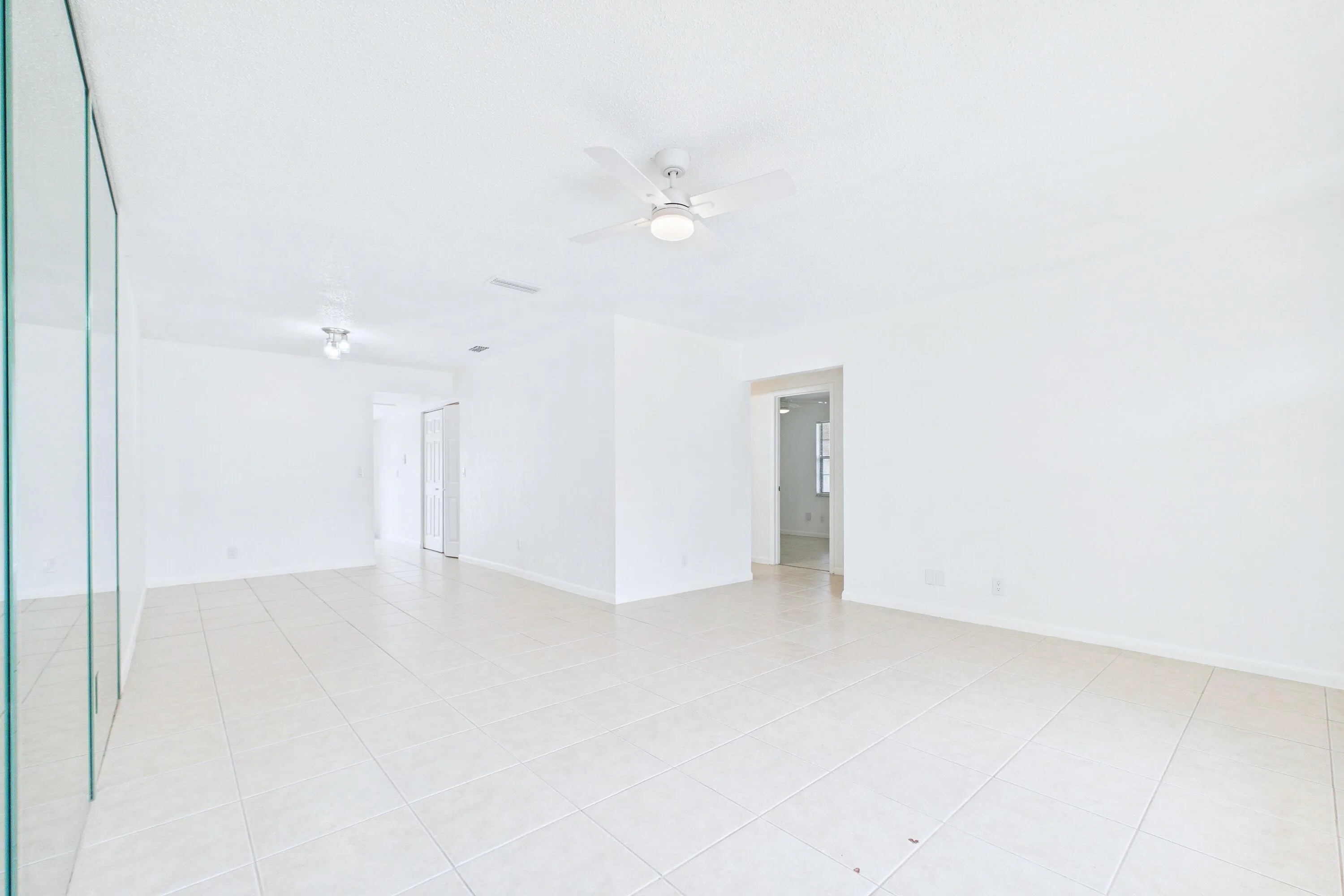Expansive room featuring tile flooring, and a ceiling fan