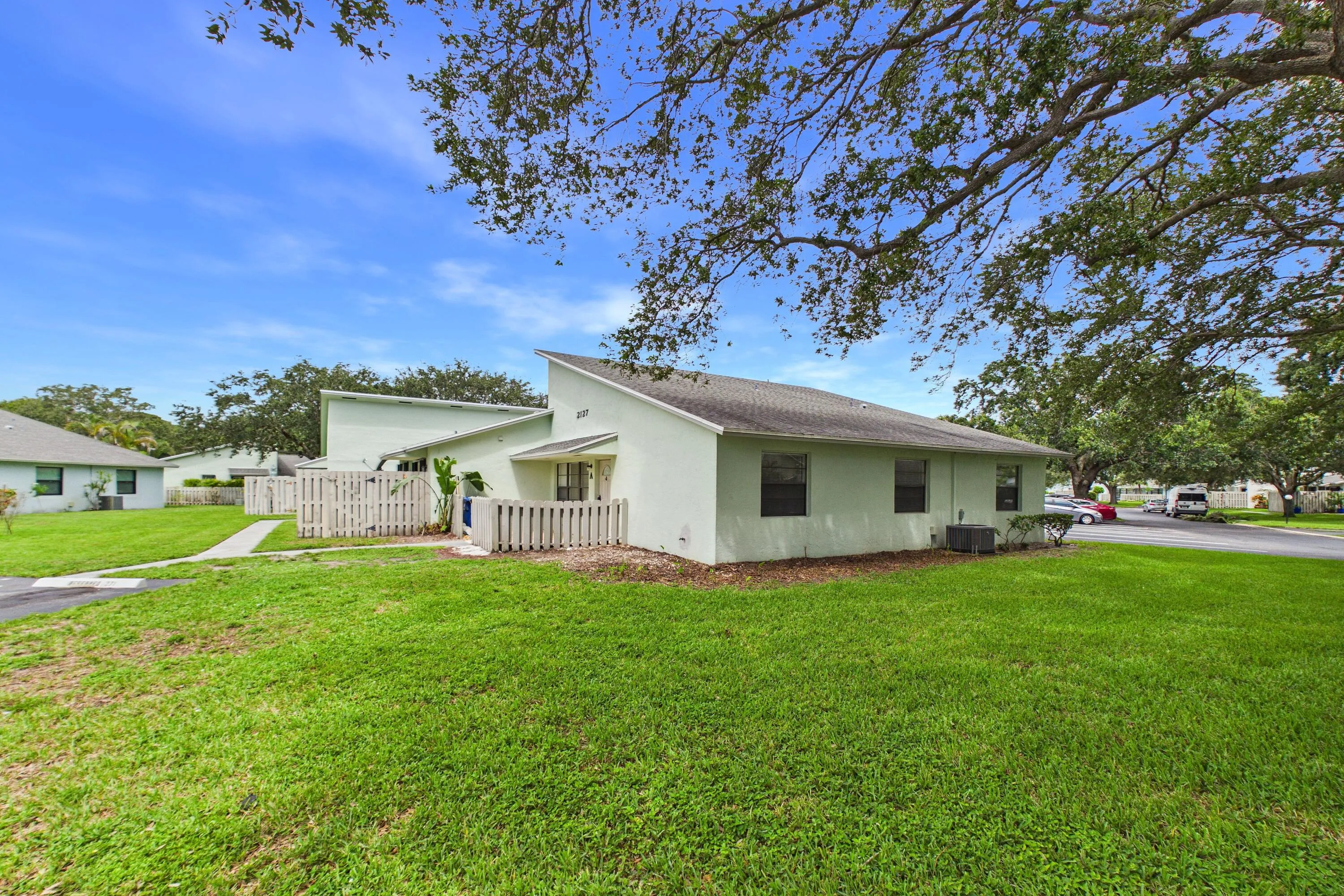 Single-story residence with a pitched roof, exterior fencing, and a grassy front yard