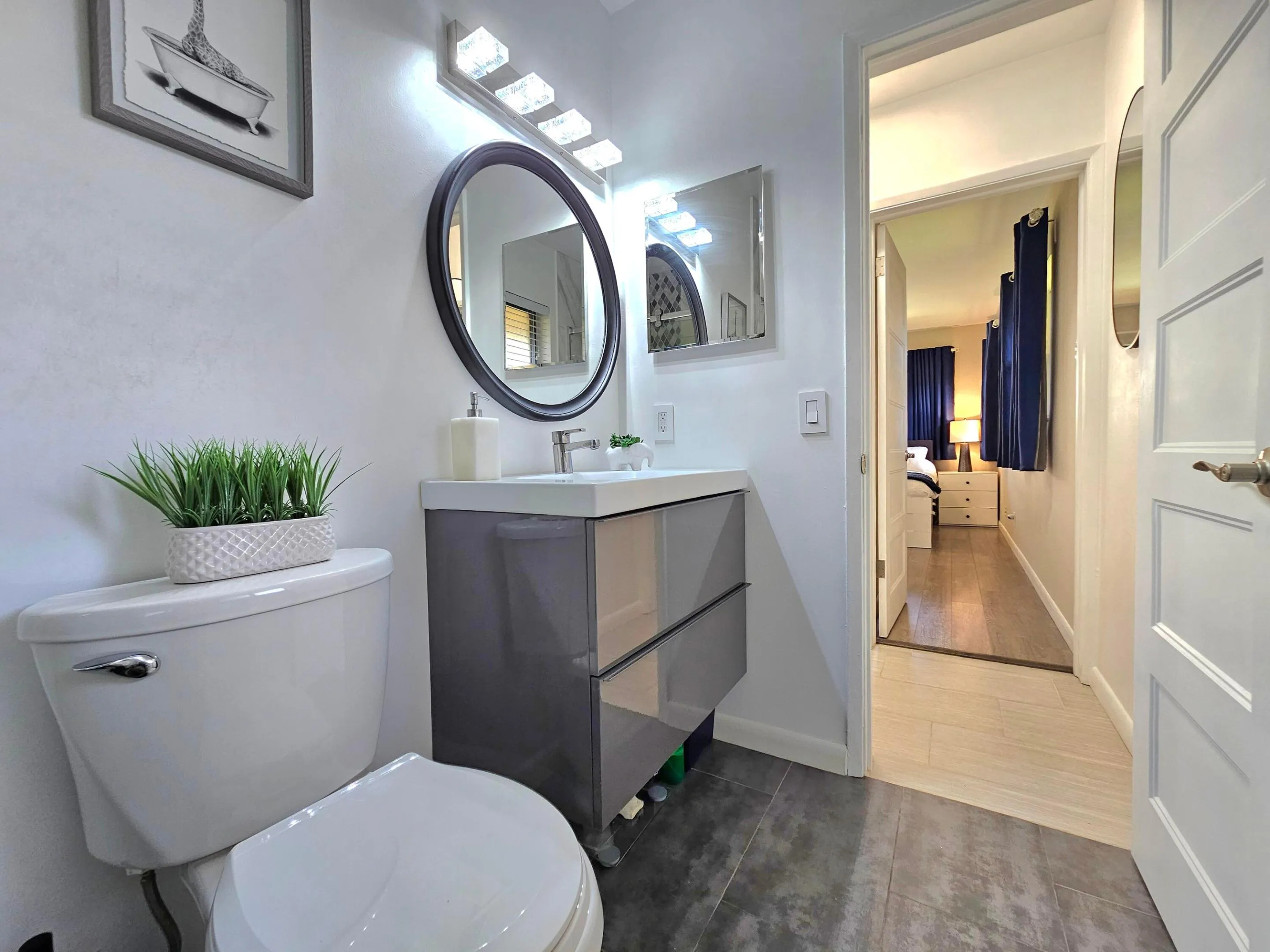 ANOTHER VIEW OF THE BATHROOM WITH SLEEK VANITY AND PLENTY STORAGE ROOM