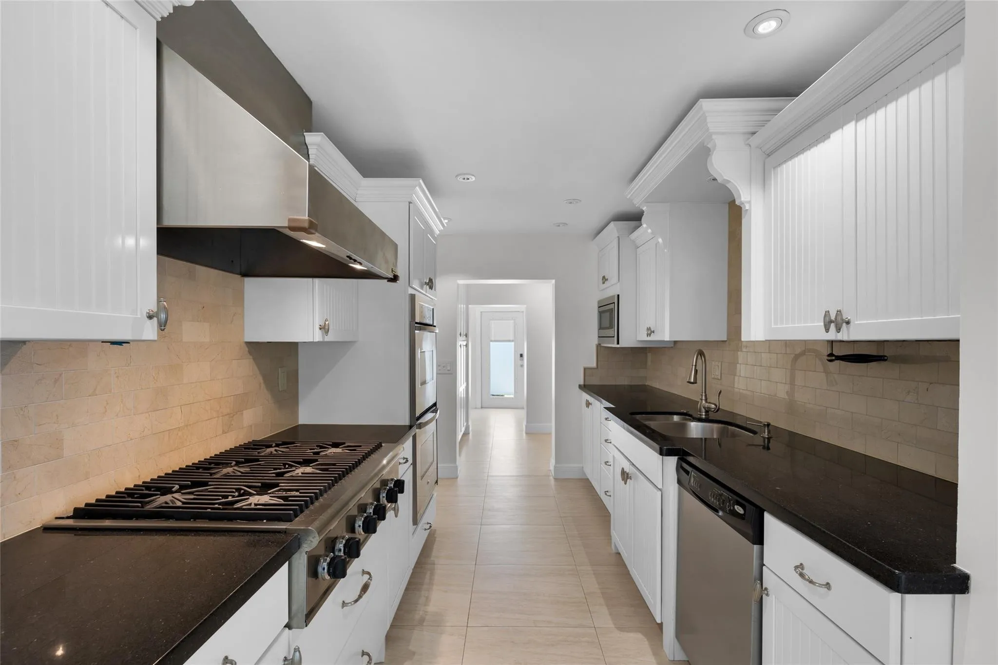 Kitchen features Granite counters, tile backsplash with white shaker counters