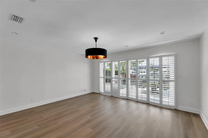 Master Bedroom with plantation shutters and pool and water views with access to backyard