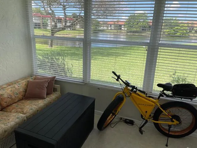 Enclosed patio with full-height windows, horizontal blinds, and a tiled floor