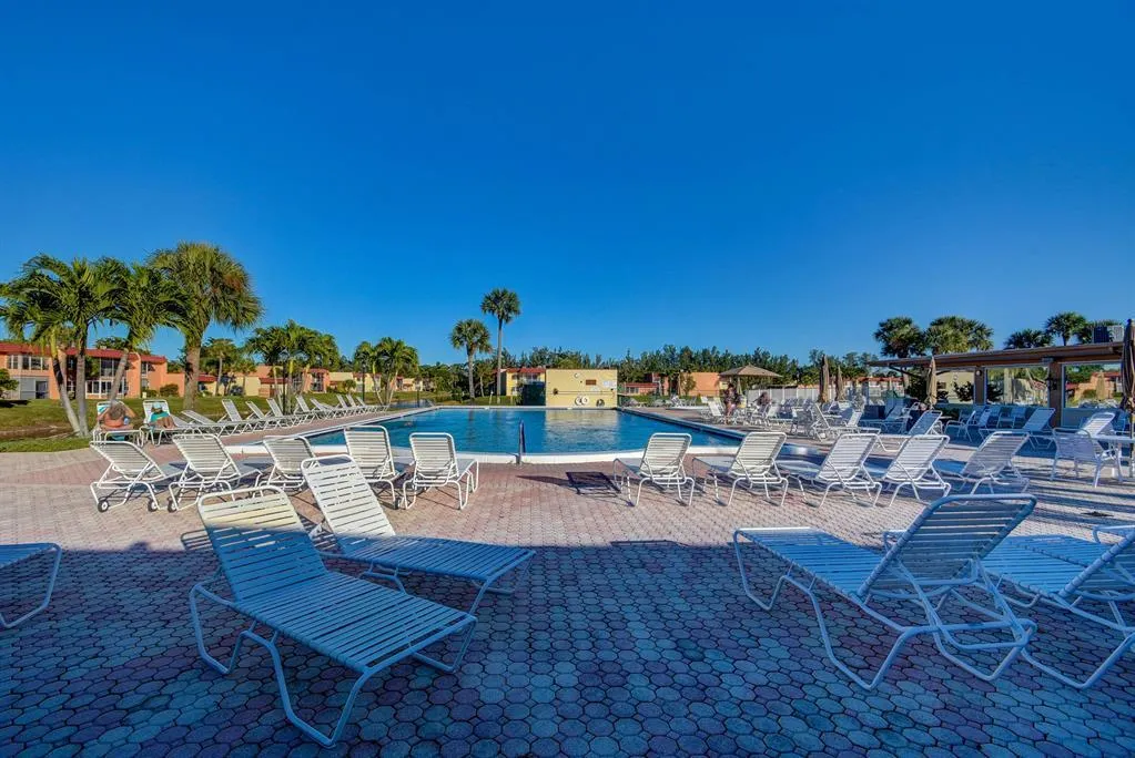 Expansive community pool with a surrounding paver patio