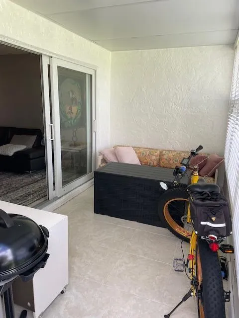 Screened outdoor living area featuring textured wall finish and tile flooring
