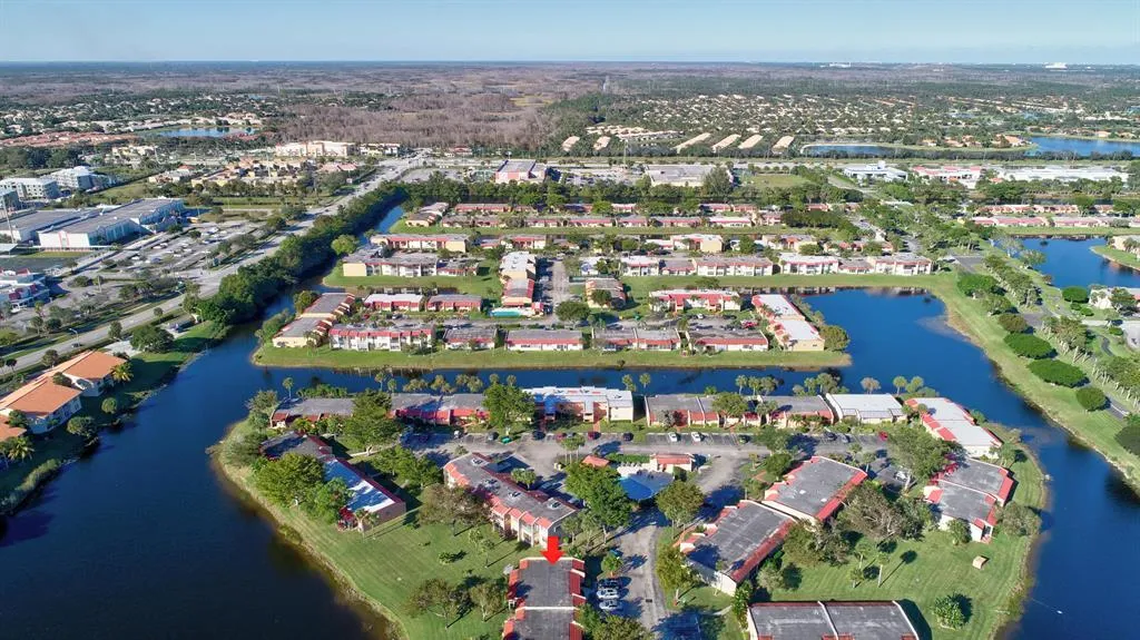 Aerial perspective featuring multiple residential structures, interconnected waterways, and developed land with roads and parking areas
